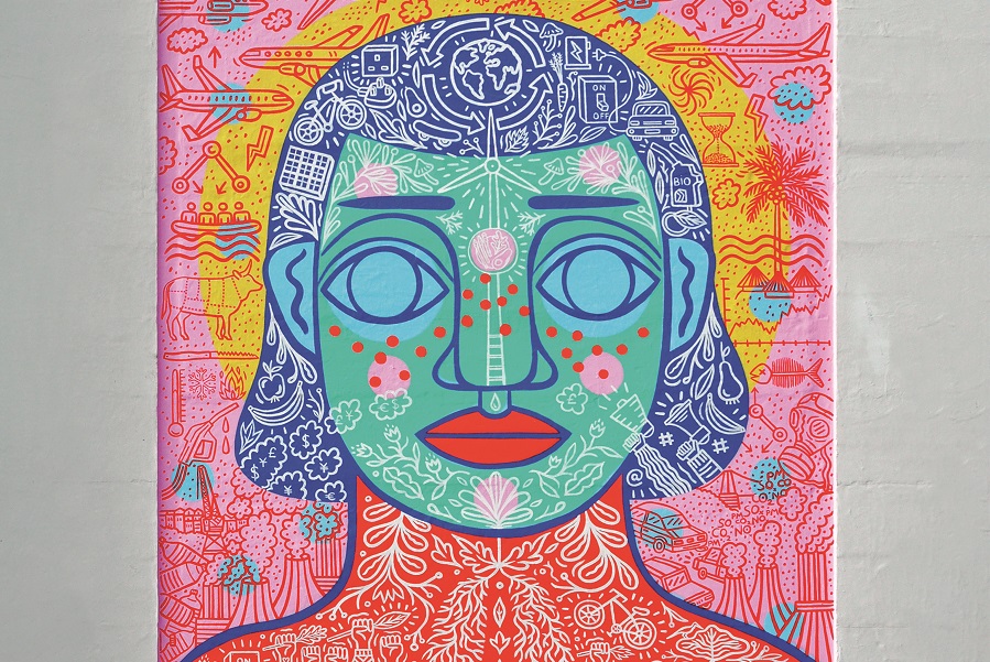 Climate change painted mural showing head and shoulders of a person covered in brightly coloured illustrations. 